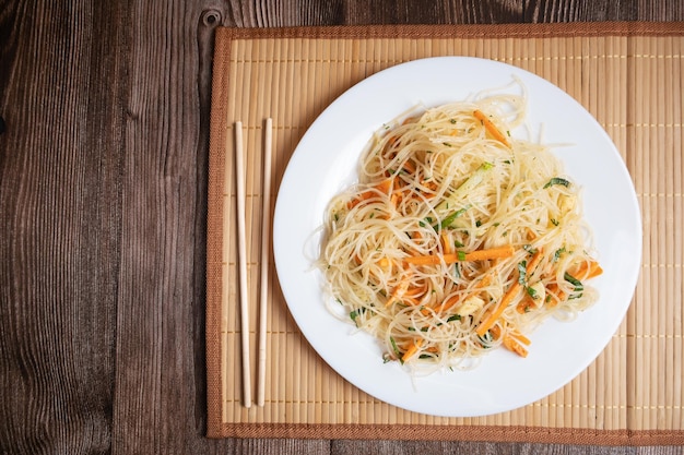 Koreanischer Funchosa-Salat mit Garnelen auf einer Bambusserviette