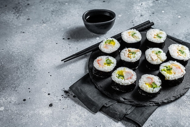 Koreanisches Sushi-Kimbap oder Gimbap aus gedämpftem weißem Reis, grauer Hintergrund, Draufsicht, Kopierraum