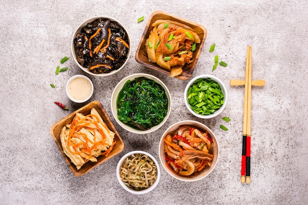 Koreanisches würziges und pflanzlich eingelegtes Essen auf grauem Hintergrund.