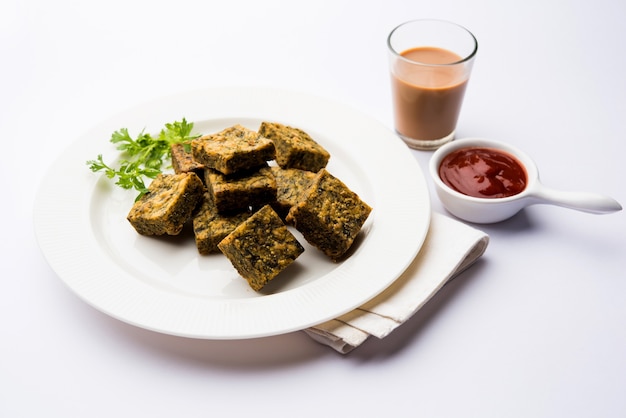 Korianderkuchen oder Kothimbir Vadi ist eine beliebte Maharashtrian-Küche aus Korianderblättern. serviert mit Tomatenketchup. selektiver Fokus