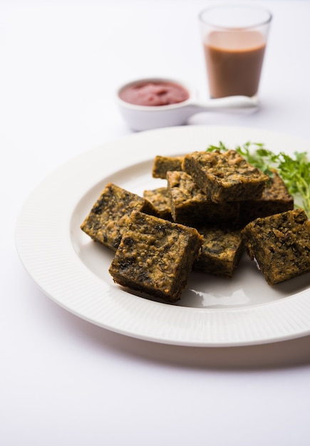 Korianderkuchen oder Kothimbir Vadi ist eine beliebte Maharashtrian-Küche aus Korianderblättern. serviert mit Tomatenketchup. selektiver Fokus