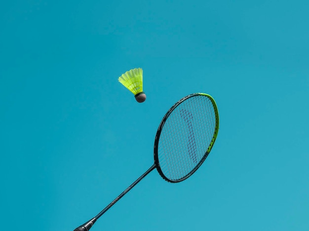 Kork und Schläger im blauen Himmel während des Badmintons
