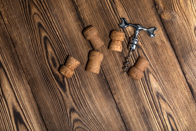 Korken und Korkenzieher auf einem alten Holztisch