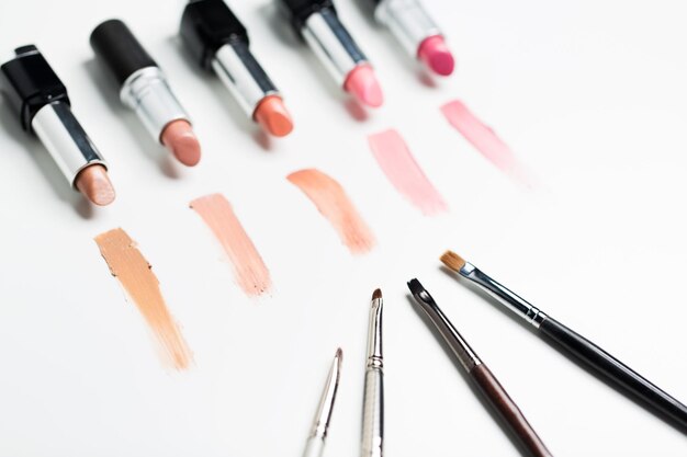 Kosmetik-, Make-up- und Schönheitskonzept - Nahaufnahme von Lippenstiften mit Pinseln