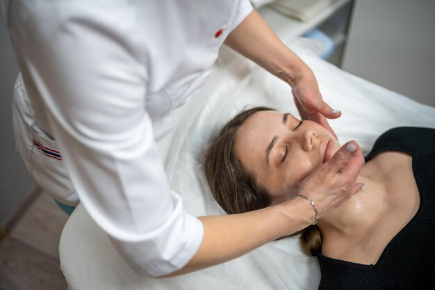 Foto kosmetiker, der einem kunden in einem spa eine gesichtsmaske auftut