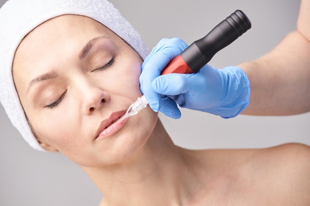 Kosmetikerin Hautpflege Gesicht Permanent Make-up Gesichtsbehandlung Frau Dermatologie Arzt Auftragen von Tattoo Mascara mit Gerät Salon-Verfahren Lippenkontur Tönung Medizinisches Konzept