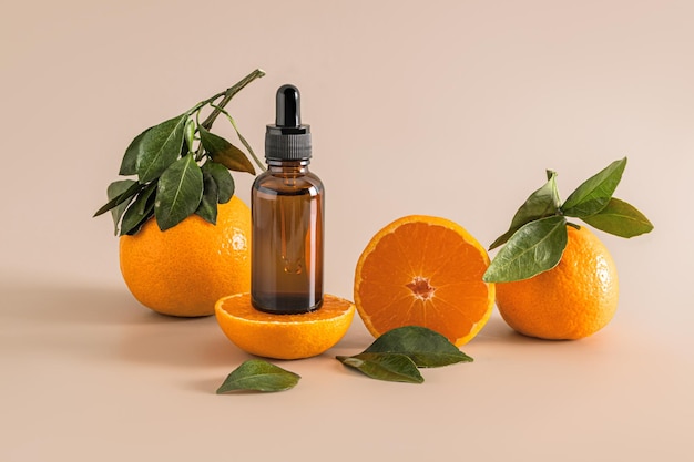 Kosmetikflasche mit Tropfer mit einem feuchtigkeitsspendenden Serum für die Hautpflege von Gesicht und Körper auf der Grundlage von Mandarine-Extrakt unter reifen Früchten Vitamin-C-Mockup