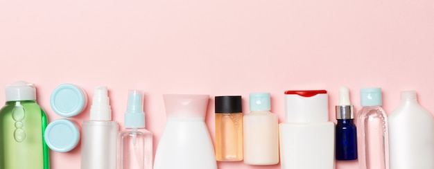 Kosmetikflaschen auf rosa Hintergrund