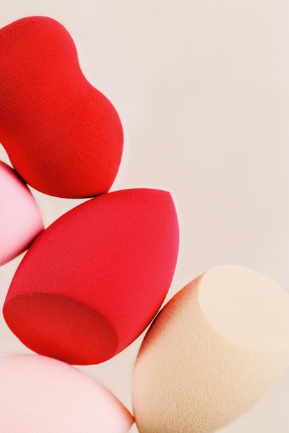 Kosmetische Beauty Blender Schwämme auf hellem Hintergrund Rot rosa gefärbte Schwämme unterschiedlicher Form Nahaufnahme