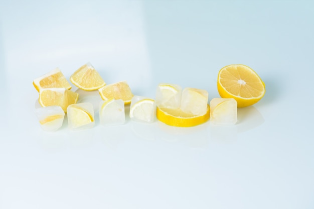 Kosmetische Eiswürfel mit Zitrone und Vitamin C für die Hautpflege auf einem Blaulichthintergrund