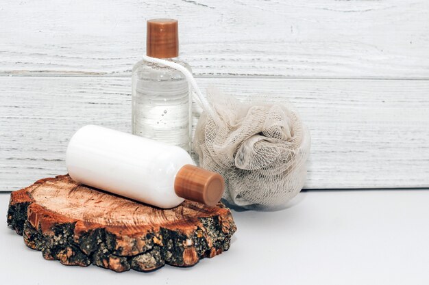 Kosmetische Flaschen für Badezimmer und Waschlappen auf Holzhintergrund.