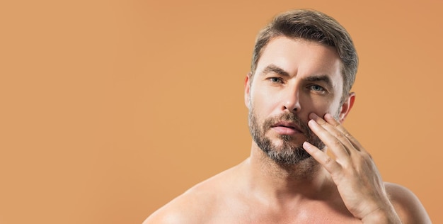 Kosmetische Hautbehandlung des Mannes auf Studiohintergrundhygiene und gesichtsreife Herrenkosmetik und Wellness