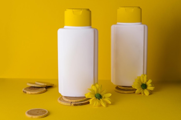 Kosmetische Produkte mit Kamillenblüten auf gelbem Hintergrund