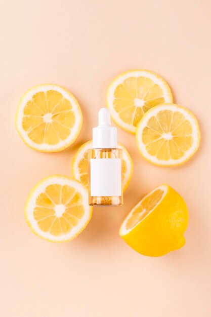 Foto kosmetischer organischer vitamin-c-extrakt schnitt aus orange, zitrone und serum tropferflasche beige hintergrund