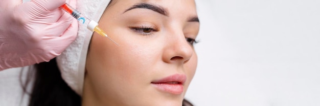 Kosmetologe macht verjüngende Anti-Falten-Injektionen im Gesicht einer schönen Frau Ästhetische Kosmetologie für Frauen in einem Schönheitssalon
