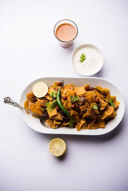 Kothu Parotta o Paratha caseros o Chapati Masala sobrante salteado o fodnichi poli en marathi, servido en un tazón o plato con cuajada y té caliente. Enfoque selectivo
