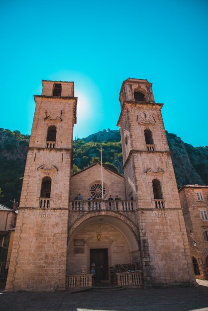 KOTOR, MONTENEGRO - 20 de julio de 2018 antigua iglesia con dos torres y turistas. concepto de viaje de verano