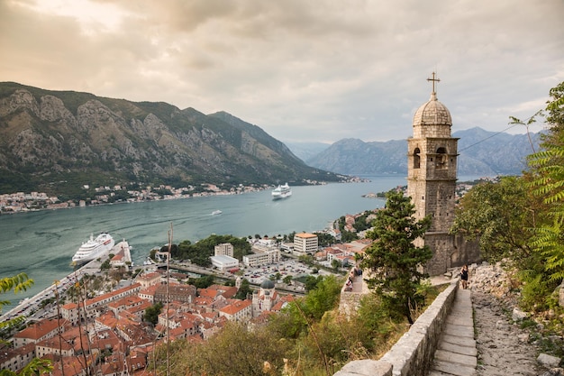 KOTOR MONTENEGRO 25. September 2016 Blick auf die Dächer der Altstadt Menschen klettern auf den Berg Lovcen und große Kreuzfahrtschiffe in einer Bucht von Kotor vom Berg Lovcen in Montenegro