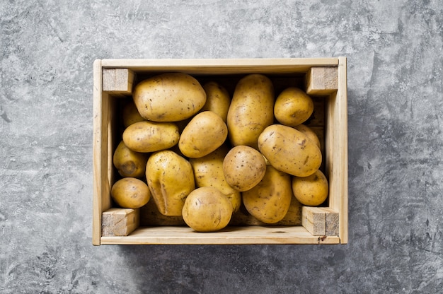 Ökoverpackung für Gemüse, kunststofffrei. Kartoffeln in einer Holzkiste, Supermarkt.