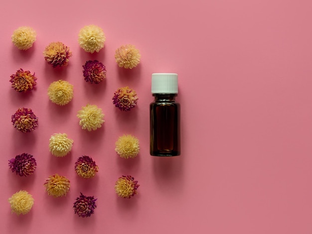 Kräuterätherisches Öl Glasflasche Modell rosa Blumen Hintergrund Alternative Medizin Hautpflege Spa