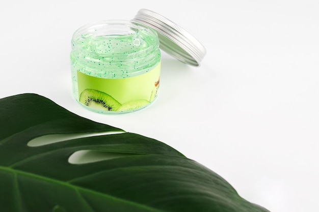 Kräuterpeeling und Kiwi-Kosmetik auf weißem Hintergrund mit grünem Palmblatt Natürliche Bio-Schönheitsprodukte Mockup