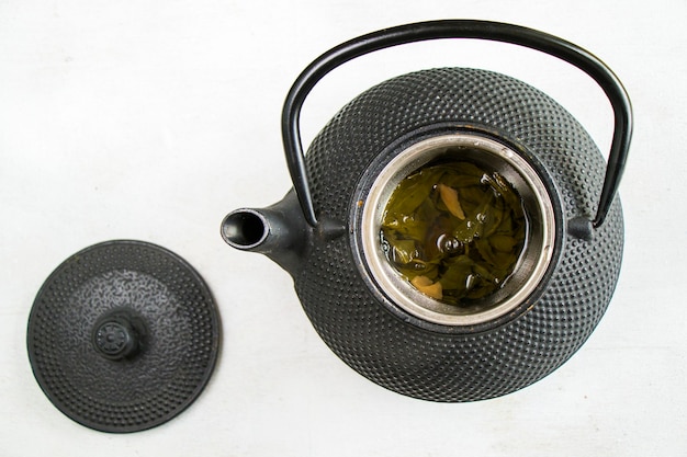 Kräutertee, eiserne Teekanne und eine Tasse Tee