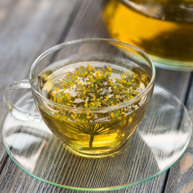 Kräutertee mit Dill in einer Glastasse im Freien