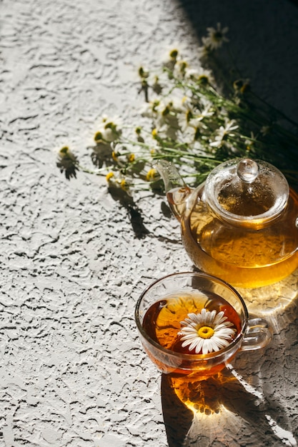 Kräutertee mit Kamille auf hellem Hintergrund