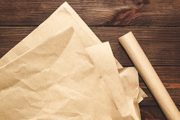 Kraftpapier in einer Rolle zum Verpacken von Paketen auf Holzhintergrund