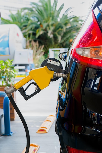 Kraftstofftankstelle gelbe Pumpe schwarze Seitenansicht des Autos