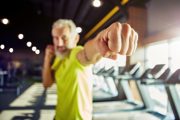 Krafttraining konzentrierte sich auf einen reifen Mann im Sportbekleidungsboxen, während er im Fitnessstudio trainierte, konzentrierte sich auf Männer