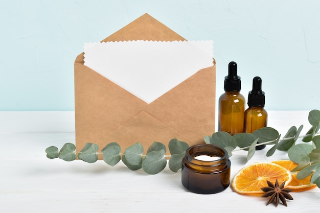 Kraftumschlag mit einem leeren Blatt und einem Layout von Naturkosmetik aus Eukalyptus mit Platz für Text. Öko-Einladung. Minimalismus. Banner für Kosmetik. Öko-Kosmetik.