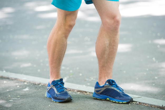 Krampfadern-Konzept verhindern. Beine des männlichen Athletenläufers, der Park-Bürgersteig joggt. Cardiotraining in richtigen Sportschuhen. Gefäßerkrankungen Krampfadern Probleme aktives Leben. Durch Laufen verursachte Krankheit.