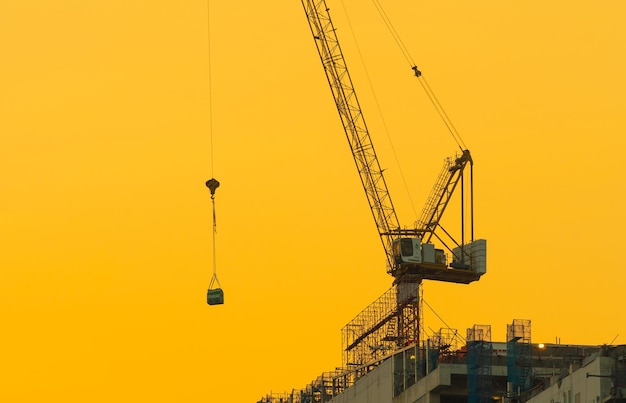 Foto kran auf der baustelle gegen den himmel bei sonnenuntergang