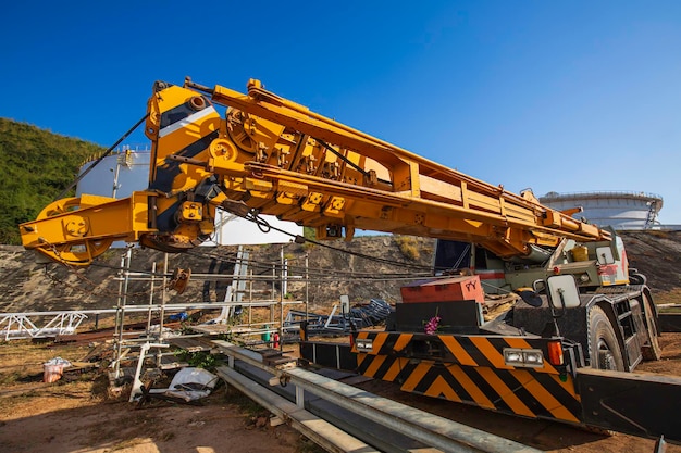 Kran auf einer Straße im industriellen Lagertank-Ölgebäude der Baustelle.