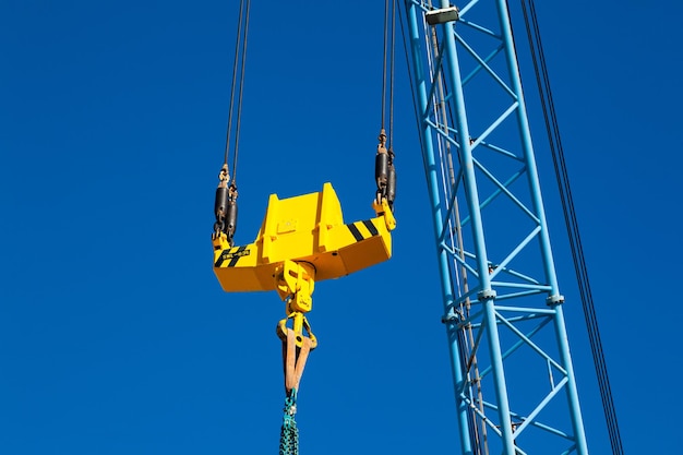 Kranausleger mit Stabilisator und Haken vor blauem Himmel