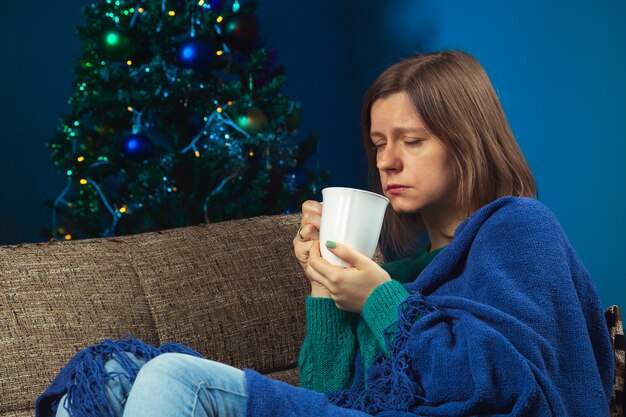 Kranke Frau am Weihnachtsabend allein in einer Wohnung in Quarantäne Konzept der Pandemieferien