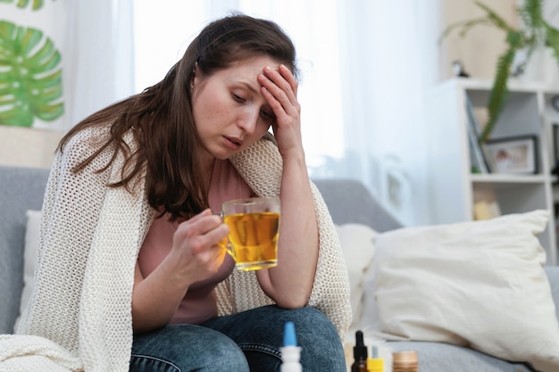 Kranke Frau, die heiße Medizin, lösliches Pulver in einem Glas Wasser trinkt