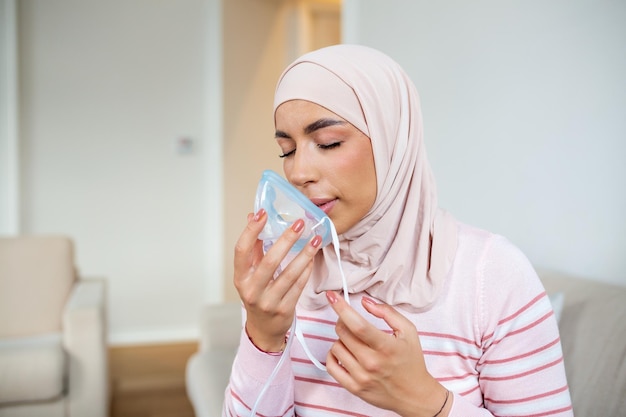Kranke muslimische Frau mit Hijab auf Sauerstoffmaske, Inhalation, Lungenentzündung, Coronavirus-Pandemie, kranke Frau, die eine Sauerstoffmaske trägt und sich einer Behandlung mit Covid 19 unterzieht