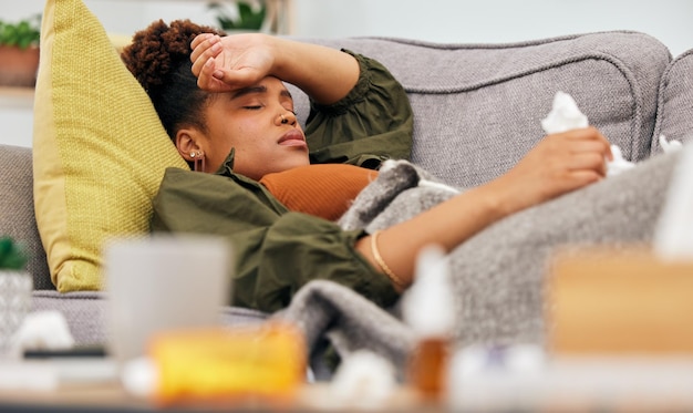 Foto kranke pillen und schwarze frau auf dem sofa mit seidenpapier-grippe und kopfschmerzen aufgrund einer virusinfektion in ihrem zuhause. bakterien-migräne und afrikanische frau mit medikamenten gegen virusmüdigkeit und übelkeit im wohnzimmer