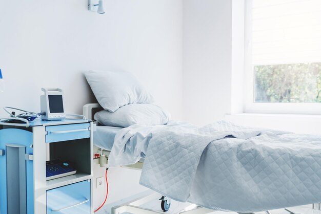 Krankenhauszimmer mit Bett und komfortabler medizinischer Ausrüstung in einem modernen Krankenhaus