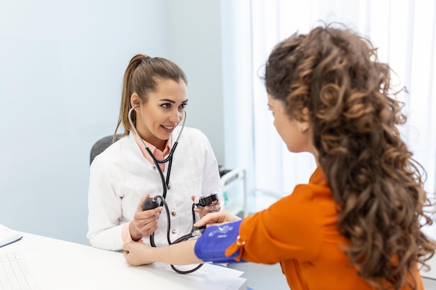 Krankenschwester, die den Blutdruck einer Patientin während einer Untersuchung in der Klinik misst. Arzt, der den arteriellen Blutdruck des Patienten überprüft