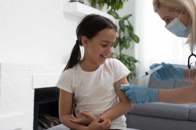 krankenschwester, die einem kleinen patienten eine impfspritze gibt.