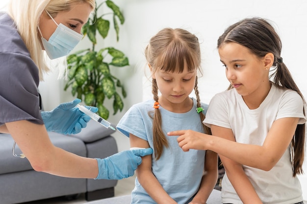 krankenschwester, die einem kleinen patienten eine impfspritze gibt.