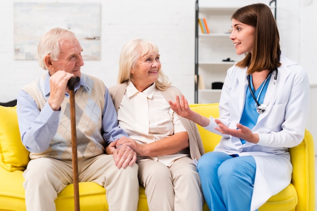 Foto krankenschwester, die mit altem mann und frau spricht