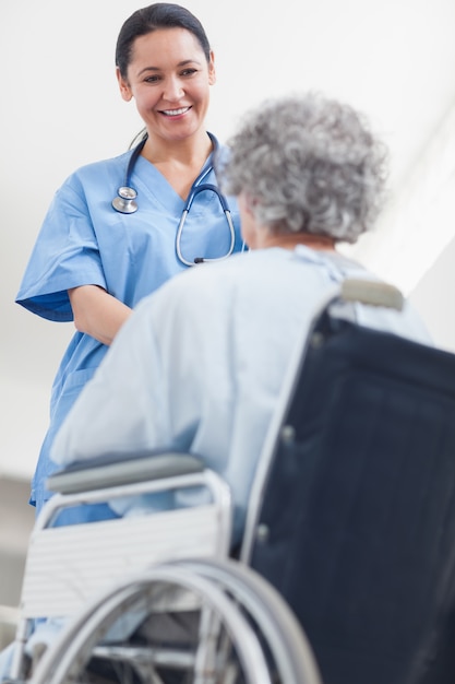 Krankenschwester, die mit einem Patienten in einem Krankenhaus spricht