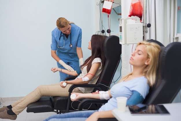 Krankenschwester, die um einen Blutspender sich kümmert