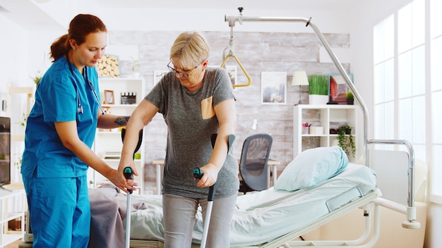 Foto krankenschwester im altersheim, die einer älteren frau hilft, ihre muskelkraft wiederzuerlangen. physiotherapie und sozialarbeiterin