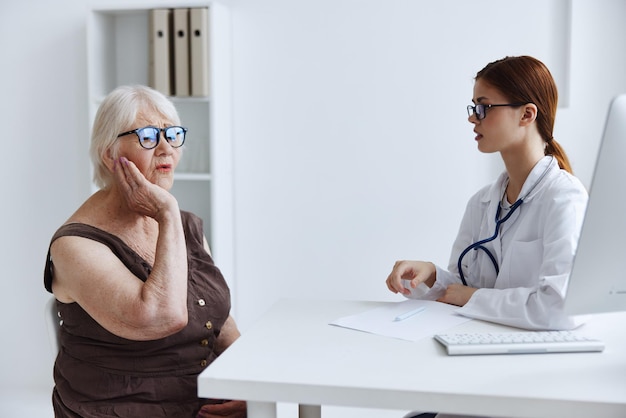 Krankenschwester in weißem Mantel unterhält sich mit dem Patienten, berät professionell, Foto in hoher Qualität