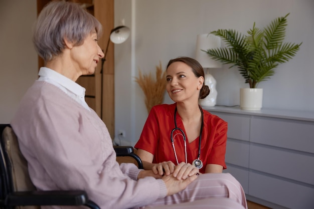 Krankenschwester oder Sozialarbeiterin und älterer Patient im Pflegeheim